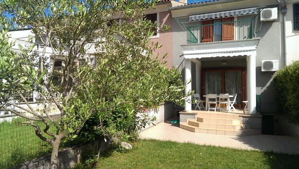 A two-story building with a balcony and a small garden area. - Apartment Anto (Umag)