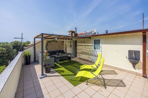 A rooftop terrace with a seating area, a water fountain, and a view of the surrounding landscape. - House Beach House (Crikvenica)
