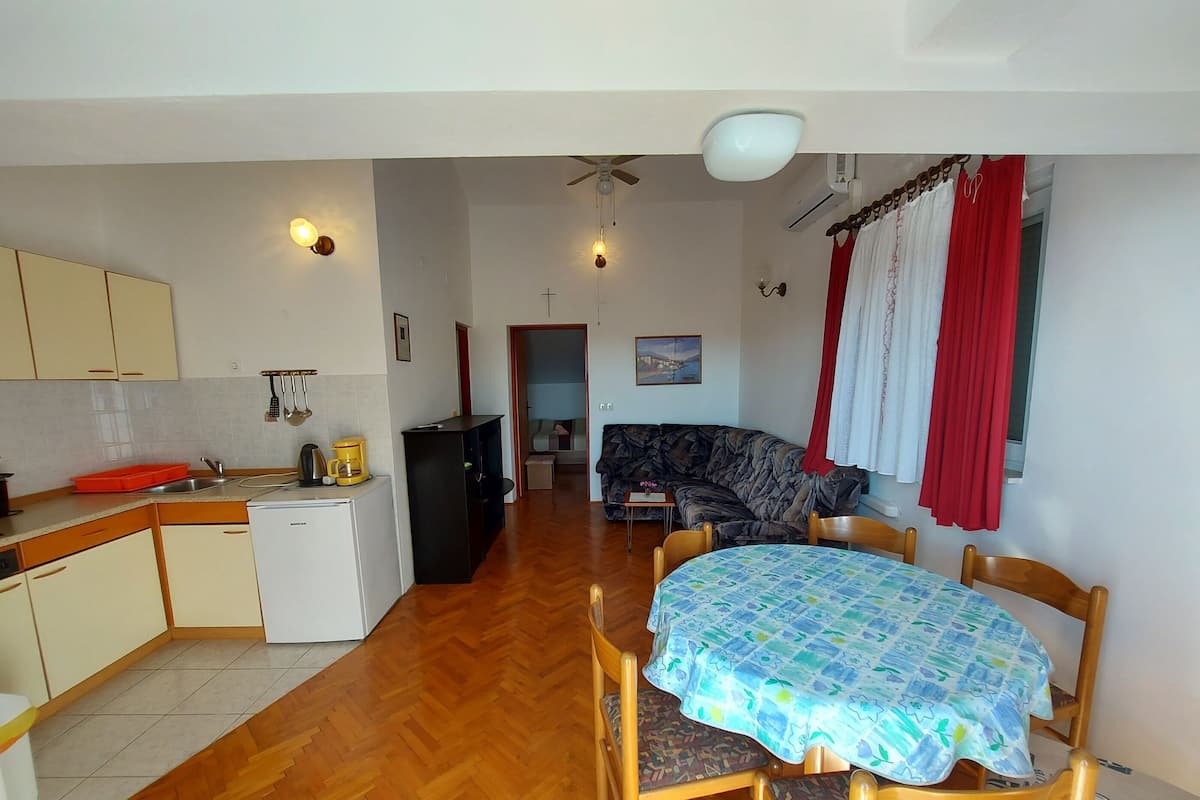 Un espacio habitable compacto con cocina, comedor y sofá.