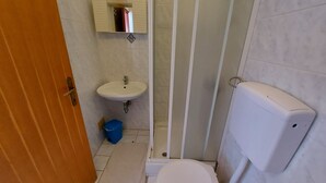 A small bathroom with a toilet, sink, and shower. - Villa Pave (Jadranovo)