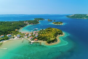 An aerial view of a coastal area with a small town, clear turquoise waters, and a variety of boats. - House Davorka (Supetarska Draga)