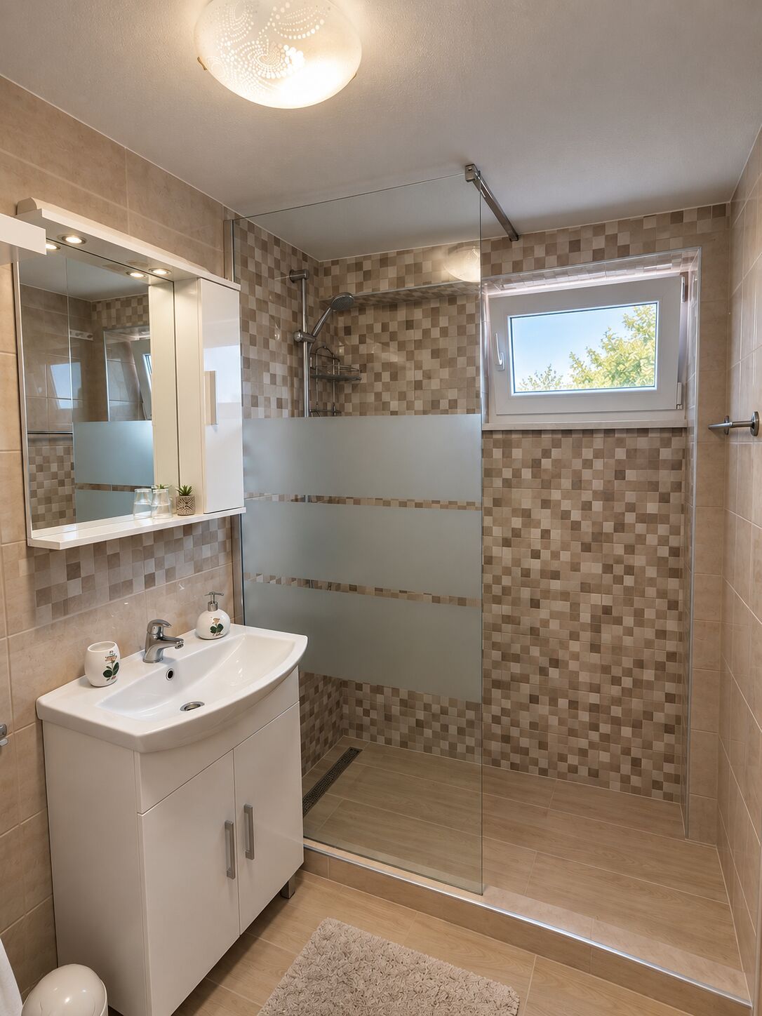 A modern bathroom with a glass-enclosed shower, a large mirror, and a sink with a cabinet.