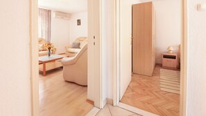 A modern living room with a sofa, coffee table, and a small side table with a lamp. - Apartments Milica (Kastel Stari)