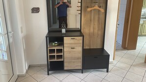 Ein moderner Waschtisch mit Spiegel, Holzvertäfelung und schwarzen Schubladen.