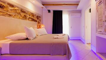Un dormitorio con cama, almohadas, una lámpara de pared y una pared decorativa de piedra.