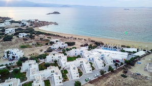A coastal area with white buildings, a beach, and a pool area. - Mikri Vigla Hotel Beach Resort (Naxos)