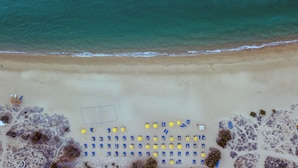 An aerial view of a beach with rows of umbrellas and chairs. - Mikri Vigla Hotel Beach Resort (Naxos)