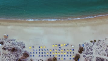 På stranden, vit sandstrand, solstolar och parasoller