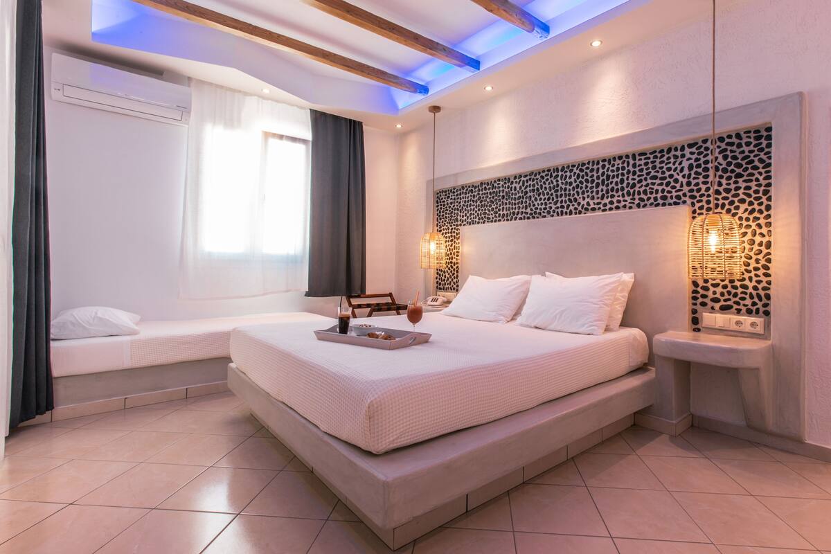 Une chambre moderne avec un grand lit, des tables de chevet et un panneau décoratif mural.