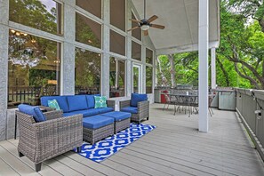 Relax in this spacious, open-plan area with a high ceiling and ceiling fan, perfect for social gatherings or unwinding with a sofa set and dining table.