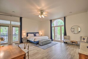 Relax in this serene bedroom with a large bed, ceiling fan, and comfortable seating area.