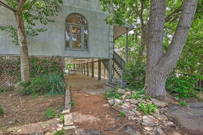 Escape to a secluded cabin nestled among lush woods, featuring a unique arched window and covered porch.