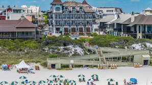 A beachfront hotel with a prominent tower, a wooden boardwalk leading to the beach, and beach umbrellas. - 🐟Walk to Beach~Pool + Corner Balcony~PRIME Location~Rollin Tide B9 (Santa Rosa Beach)