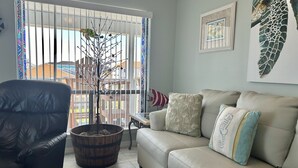 A living room with a leather sofa, a wooden coffee table, and a potted plant.