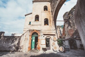 A historic building with a central tower, arched windows, and a green door.