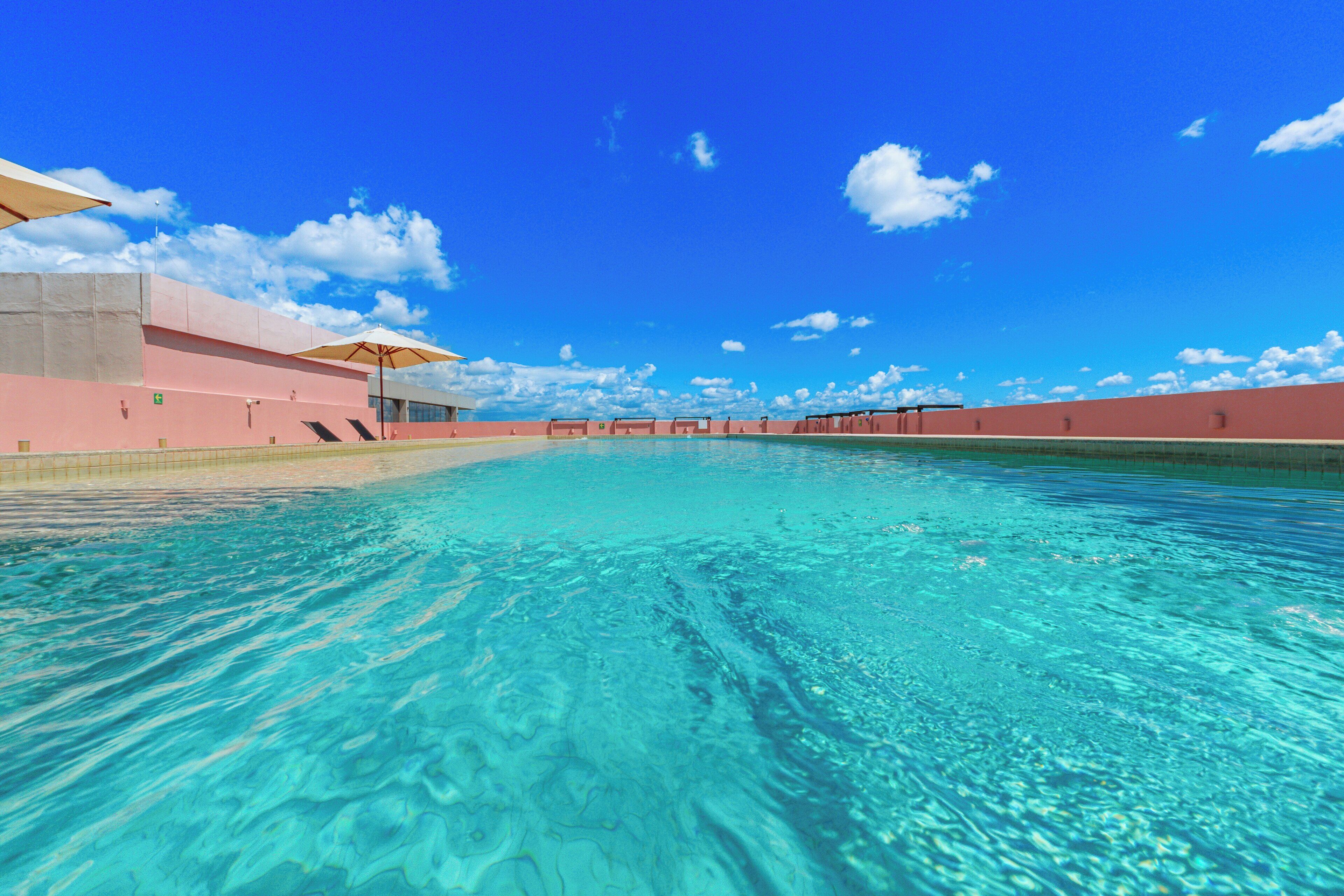 Alberca al aire libre, sombrillas en la alberca y camastros 