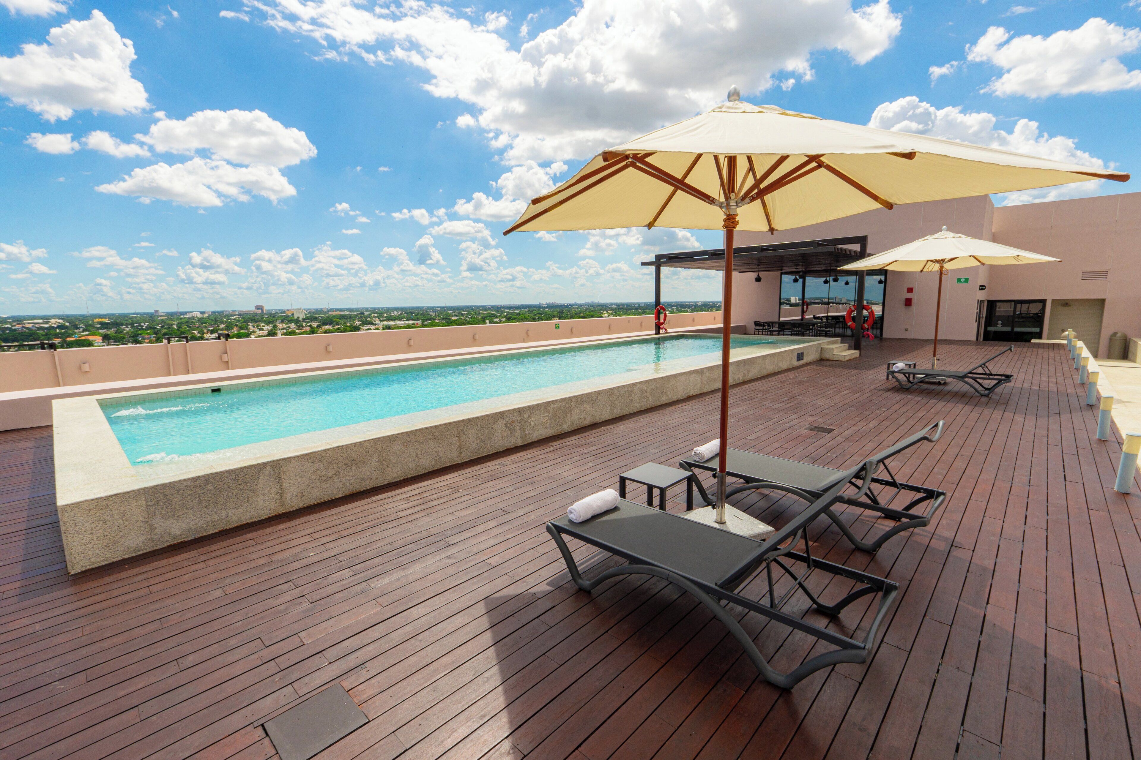 Alberca al aire libre, sombrillas en la alberca y camastros 