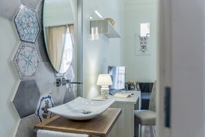 Een moderne badkamer met een grote spiegel, een wit wastafelmeubel en een houten kast.