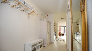 A hallway with a white bench, a drying rack, and a wardrobe. - Papillon Wohnung 07-2 (Ostseebad Boltenhagen)