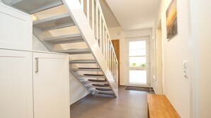 Eine Treppe mit hölzernem Geländer und weißen Wänden.