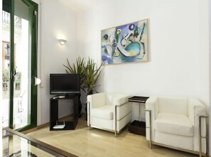 Relax in this stylish living room with a flat-screen TV, comfortable sofa, and a beautiful abstract painting.