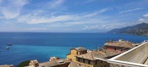 Eine Küstenstadt mit Gebäuden mit Blick auf das Meer, Booten und einem klaren Himmel.