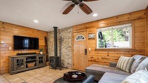 Una sala de estar acogedora con chimenea, televisión y un amplio ventanal.