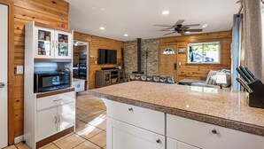 A modern kitchen with a granite countertop, white cabinetry, and a built-in stove.