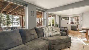 Amplia sala de estar con un sofá modular grande, techo de madera y vistas al exterior.