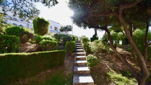A stone staircase surrounded by greenery, leading to a white building with blue accents. - Premium Holiday House  (Torrevieja)