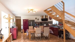 A spacious kitchen with a dining area, wooden staircase, and modern appliances. - La plage à pied - Plouhinec (Plouhinec)