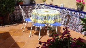A patio with a round table and chairs, surrounded by a tiled wall with a blue and white pattern. - Torremolinos in el Pinar LONG TERM RENT INDEPENDENT house with pool  (Torremolinos)