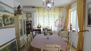 A dining room with a round table, chairs, a chandelier, and a window with curtains. - Torremolinos in el Pinar LONG TERM RENT INDEPENDENT house with pool  (Torremolinos)