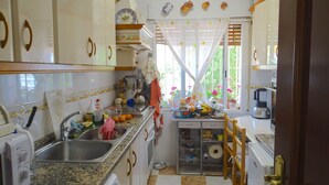 A kitchen with granite countertops, stainless steel appliances, and a window with a curtain. - Torremolinos in el Pinar LONG TERM RENT INDEPENDENT house with pool  (Torremolinos)