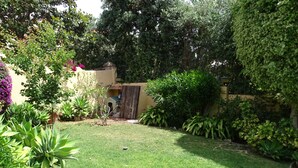 A well-maintained garden with a variety of plants and a small doghouse. - Torremolinos in el Pinar LONG TERM RENT INDEPENDENT house with pool  (Torremolinos)