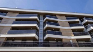 A multi-story building with a modern architectural design, featuring balconies and large windows. - La Concha Terrace - The Rentals Collection (San Sebastián)
