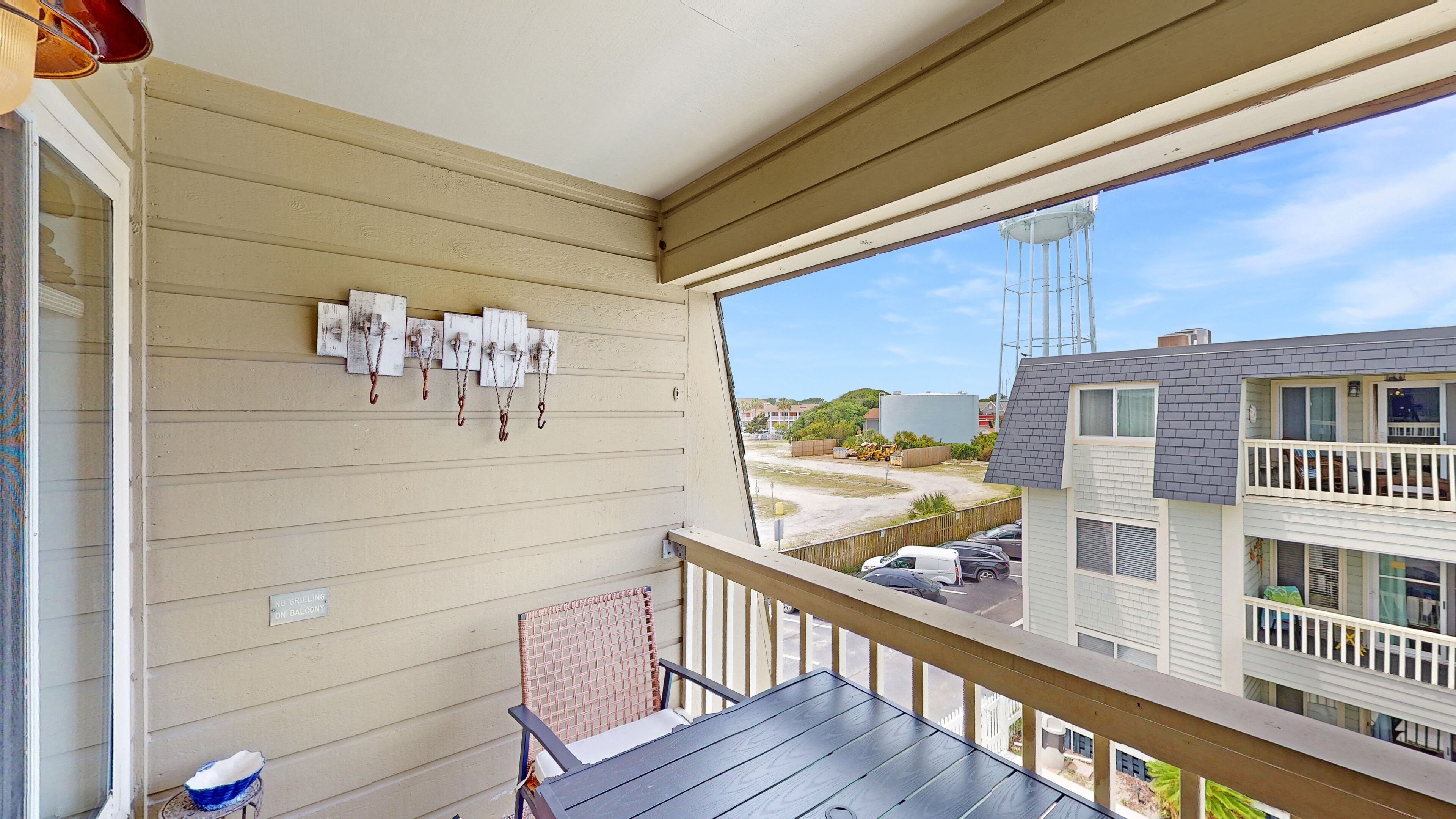 A balcony with a view of a parking lot and a water tower.