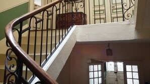 Un escalier avec une rampe en bois et des balustres en métal noir.