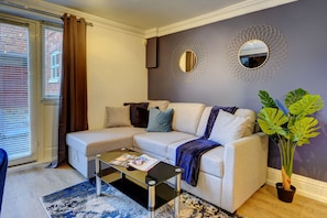 Relax in this stylish living room with a comfortable sofa, coffee table, and potted plant.