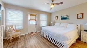 A bedroom with a large bed, a ceiling fan, and two windows with blinds. - SeaCliffs North Cape San Blas (Cape San Blas)