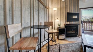 A cozy living room with a fireplace, a television, and a view of the outdoors. - Ten Mile Creek 304 2 Bedroom Condo by RedAwning (Frisco)
