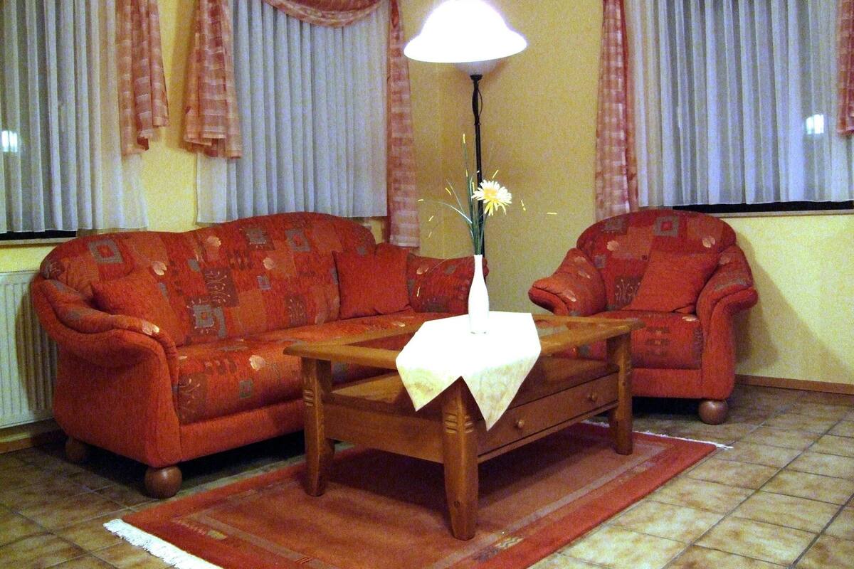 Una sala de estar con un sofá, una mesa de centro y una lámpara.