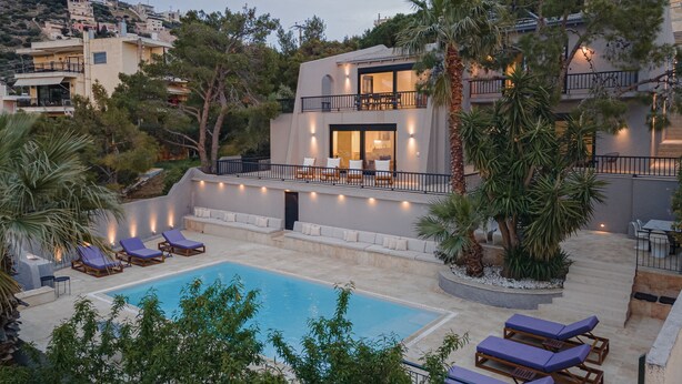 A modern two-story building with a swimming pool, outdoor seating, and a balcony. - Athenian Black Villa (Saronikos)