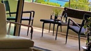 Een balkon met buitenmeubilair en uitzicht op de oceaan.