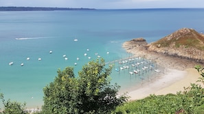Un paysage côtier avec des bateaux, une côte rocheuse et une végétation luxuriante.