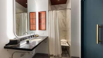 Une salle de bain moderne avec un double lavabo, un grand miroir, une douche avec rideau et une porte bleue.