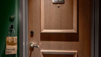 A wooden door with a brass handle and a brass plate reading "No. 211".