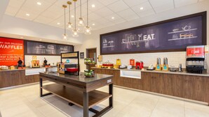 Un café moderne avec un comptoir en bois, un tableau noir servant de menu et une machine à café.