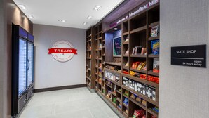 Un couloir d’hôtel avec une pancarte indiquant « OFFRES SPÉCIALES » et une autre indiquant « BOUTIQUE DE SUITES ».