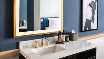 Une salle de bain moderne avec un grand miroir, deux vasques et un meuble-lavabo foncé.